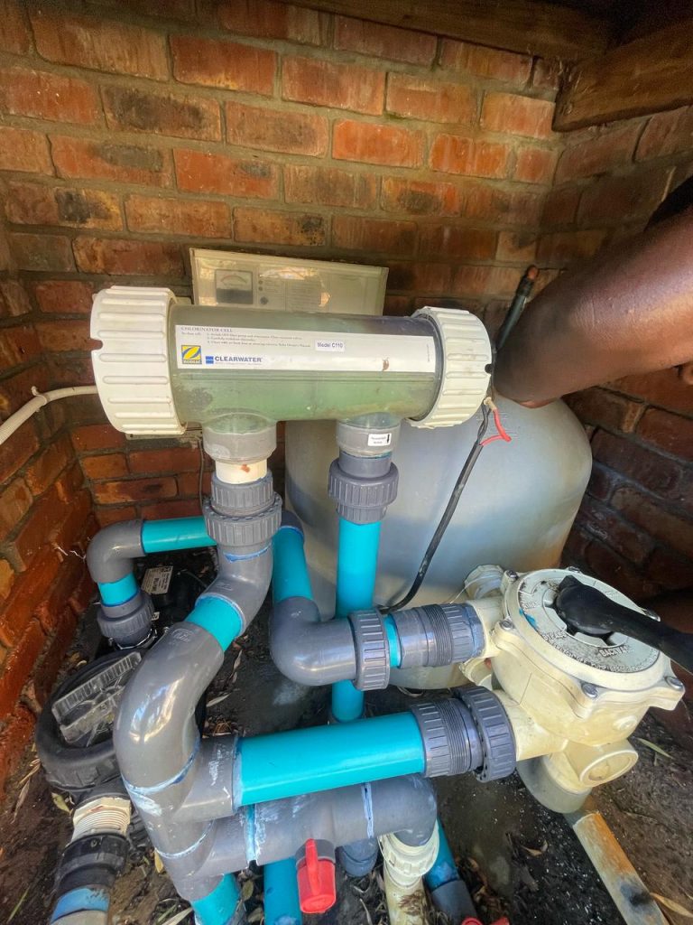 Experienced pool technician inspecting a pool's equipment.
