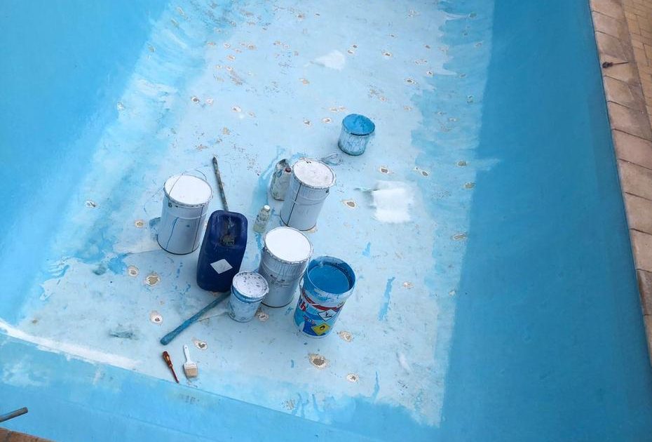 Technician repairing fibreglass pool shell with fungal contamination in Cape Town