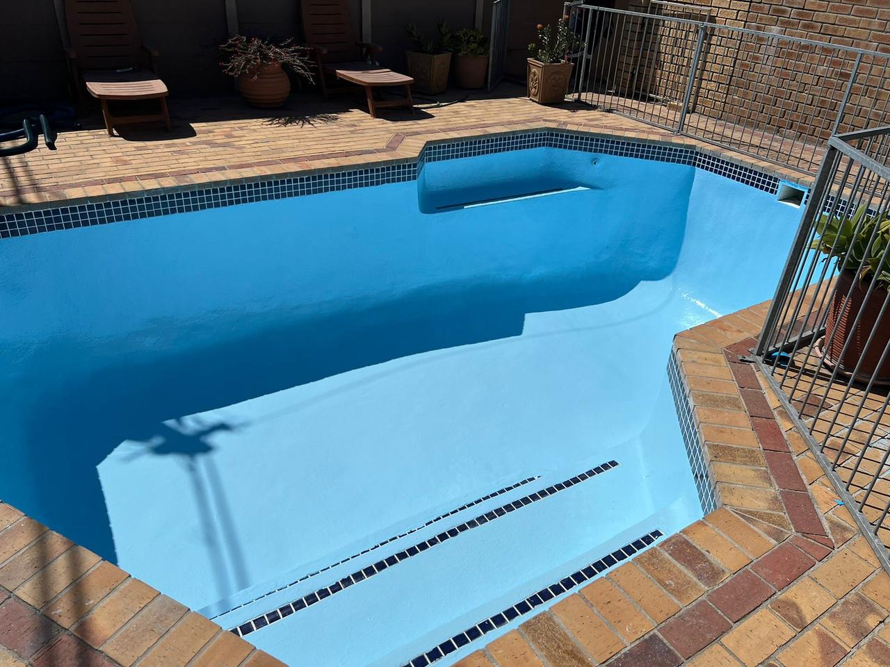 Freshly relined blue pool with brick coping in Cape Town