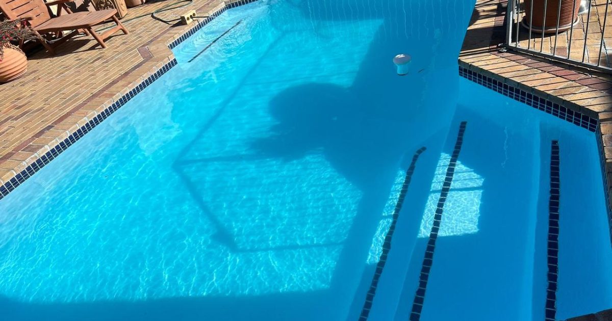 Fully installed fibreglass pool shell in a Cape Town backyard with clean blue finish