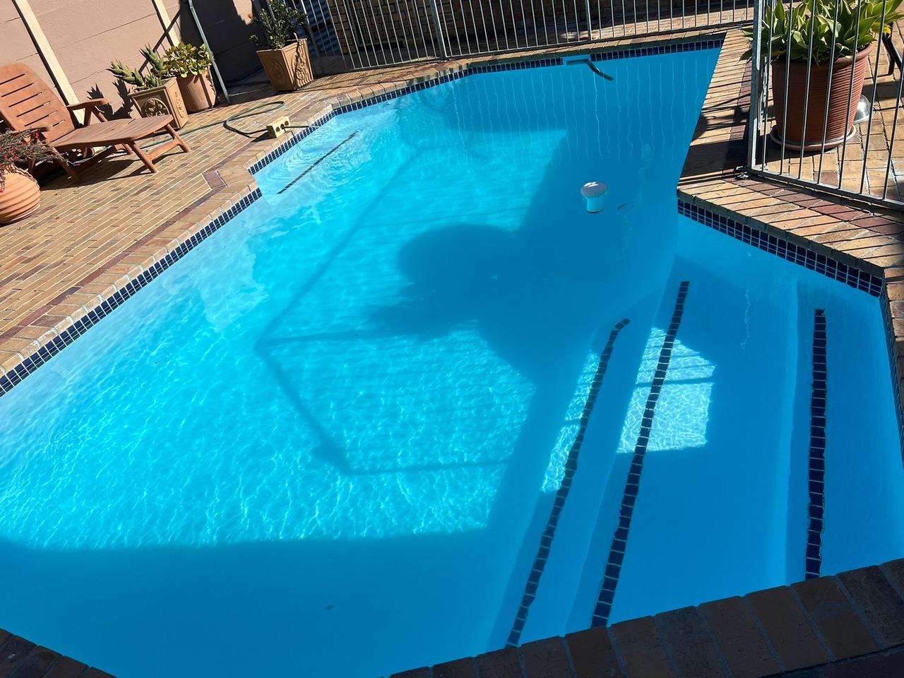 Fully installed fibreglass pool shell in a Cape Town backyard with clean blue finish