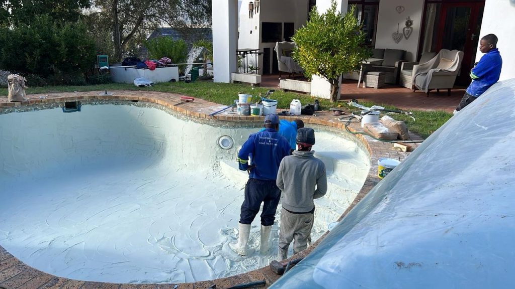 Gunite swimming pool showing signs of surface damage, cracks, and aging before undergoing professional relining.
