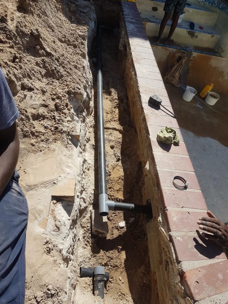 Pool pipework dug out along the pool wall during a pool leak repair