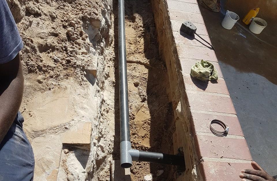 "Pool jet piping leak detection and repair services, with technician inspecting and fixing pipe issues."