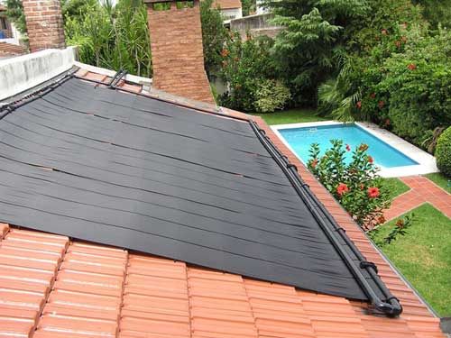 "Solar pool heater panels mounted on a rooftop for energy-efficient swimming pool heating"