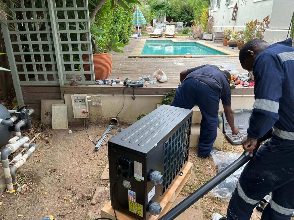 "Technicians installing a pool heat pump in Somerset West, Cape Town, ensuring efficient heating."