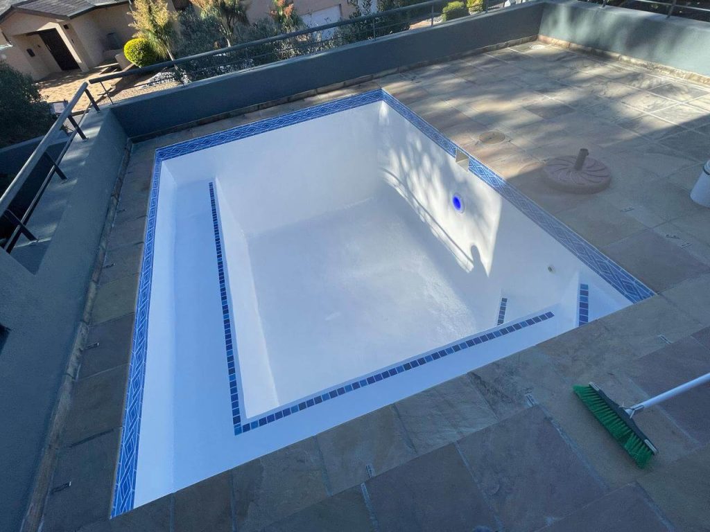 Fully restored fibreglass swimming pool with a smooth, glossy interior and vibrant blue finish after expert relining service.