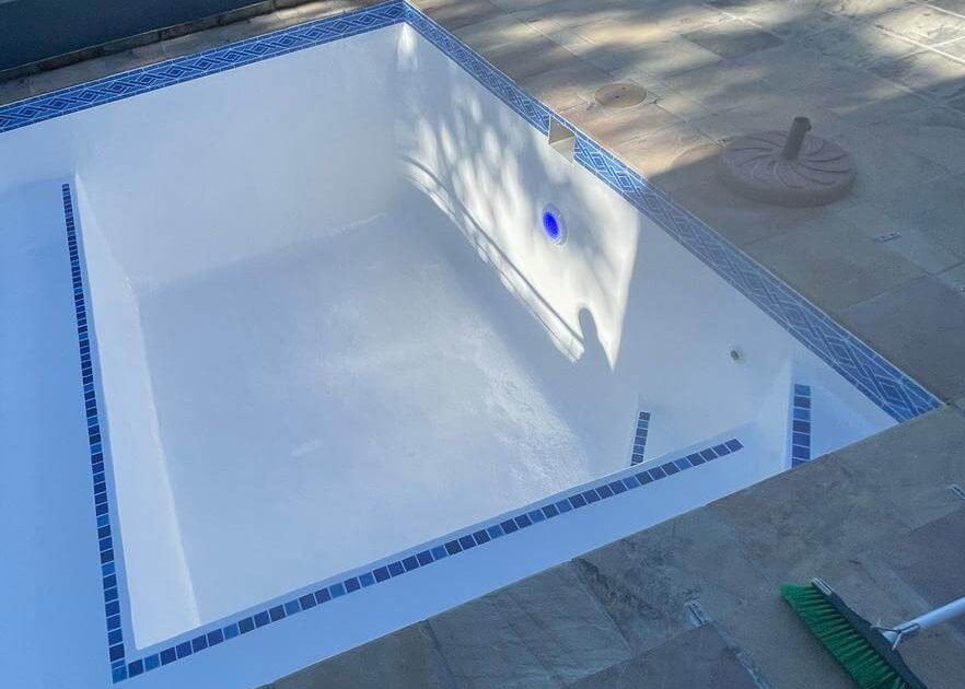 Beautiful newly renovated white fibreglass lined swimming pool in Piketberg, Western Cape with crystal clear blue water and modern resurfaced finish.
