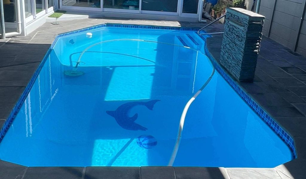 Newly renovated swimming pool in Darling with modern fibreglass finish, clear blue water, renovated coping and outdoor entertainment area by Pools Reno Western Cape
