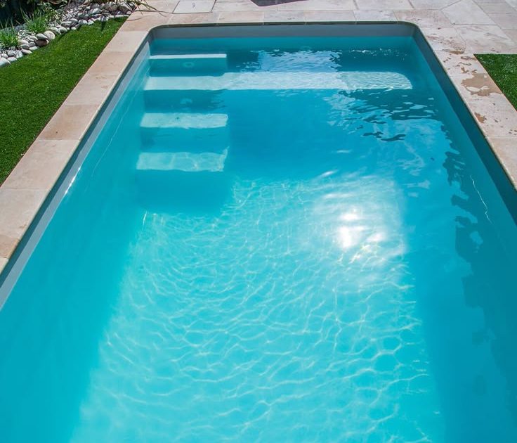 Beautiful custom-designed pool sparkling under the sun in a modern Cape Town backyard, surrounded by stylish landscaping and outdoor lounging areas.