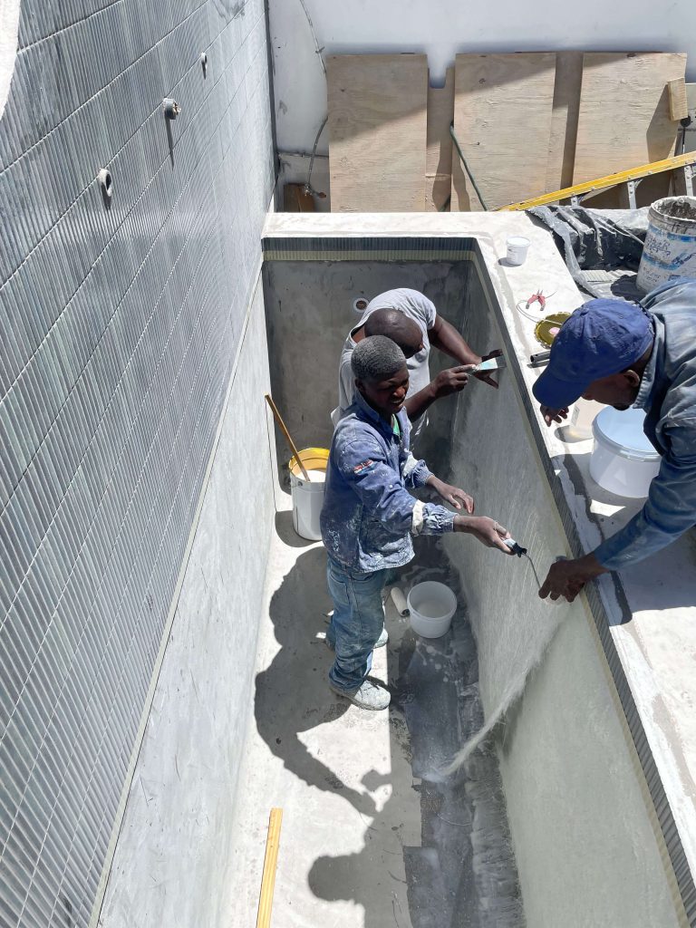 "Custom-built concrete pool undergoing fibreglass lining installation, showcasing precision and craftsmanship."