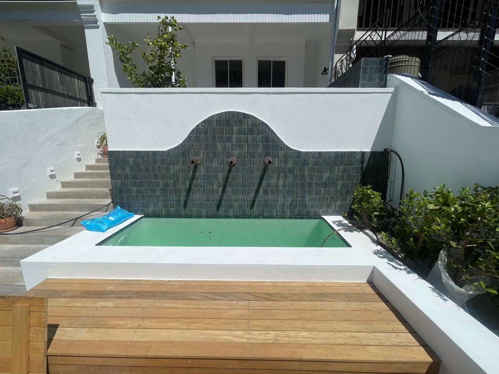 "Custom-built concrete and fibreglass-lined pool completed, offering a sleek and durable finish."
