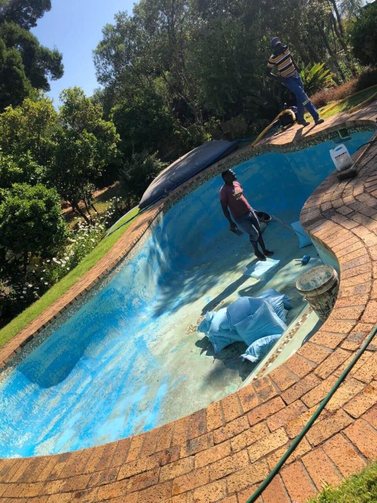 "Gunite swimming pool before relining, showing worn surface and structural preparation."