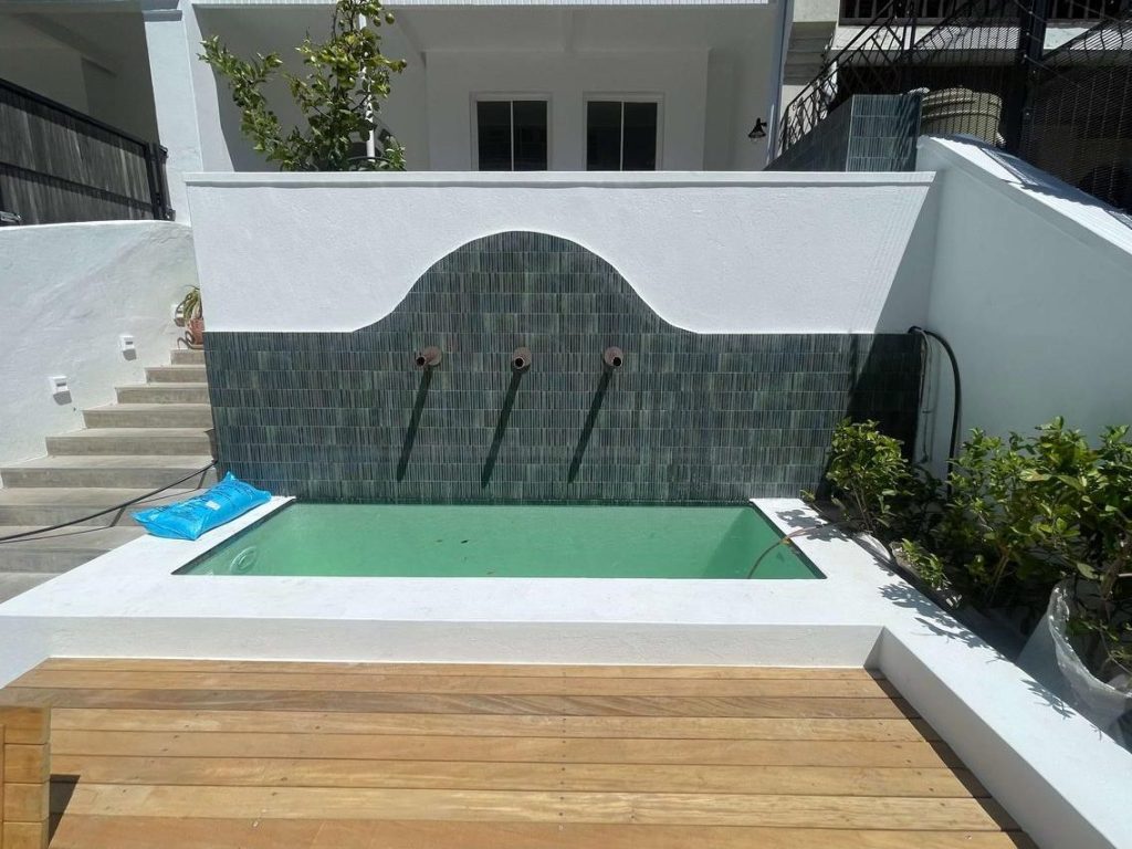 “Newly renovated swimming pool with LED lights and wood deck in Franschhoek guesthouse.”