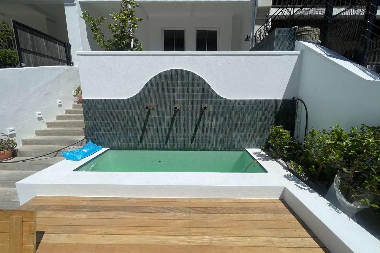 “Custom pool renovation with waterfall and lighting features in Franschhoek.”