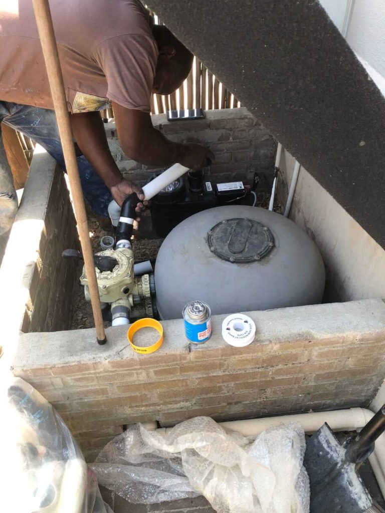 Technician repairing a pool pump in Cape Town.
