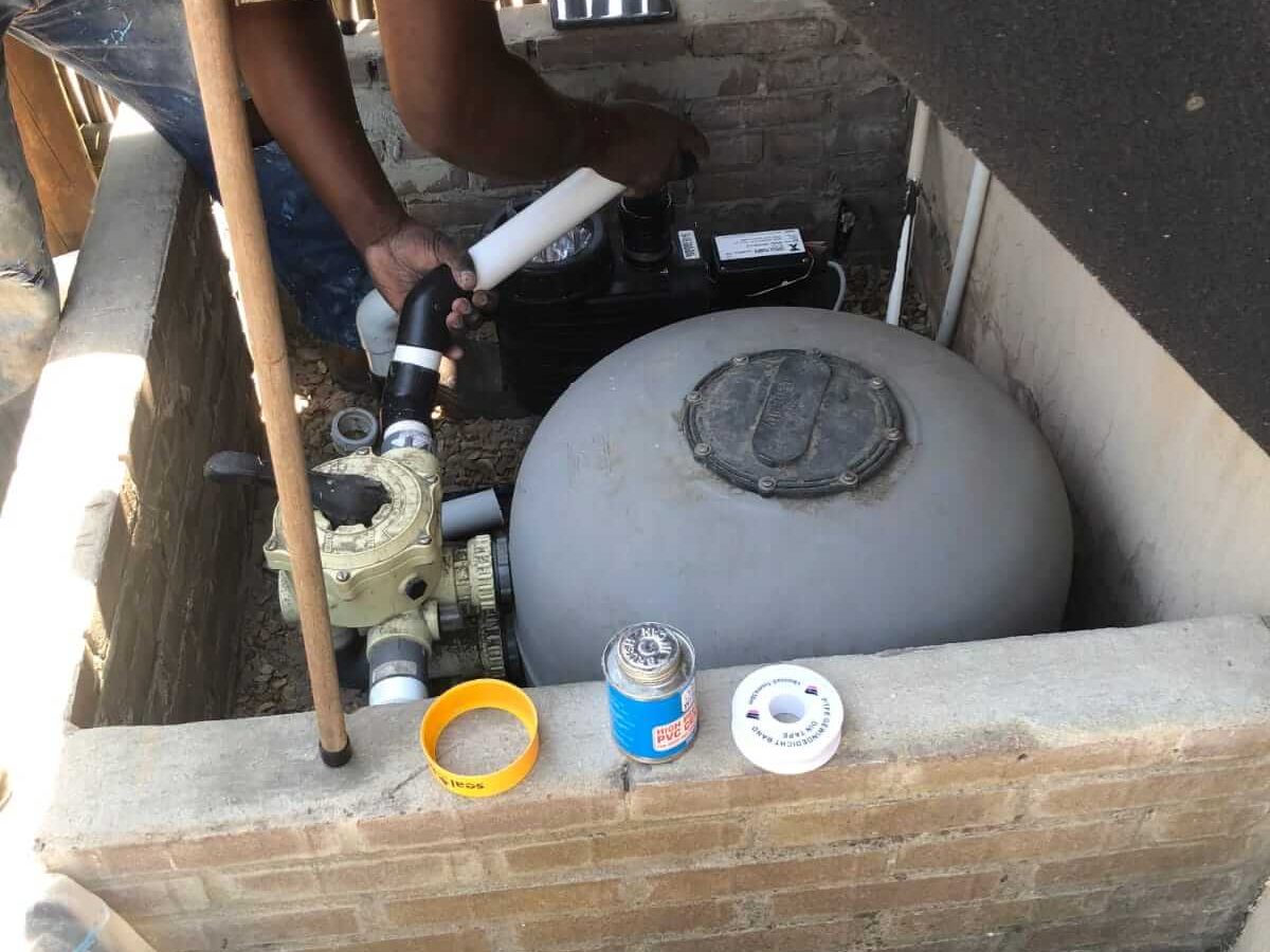 Pool technician repairing a pool pump system in Somerset West home
