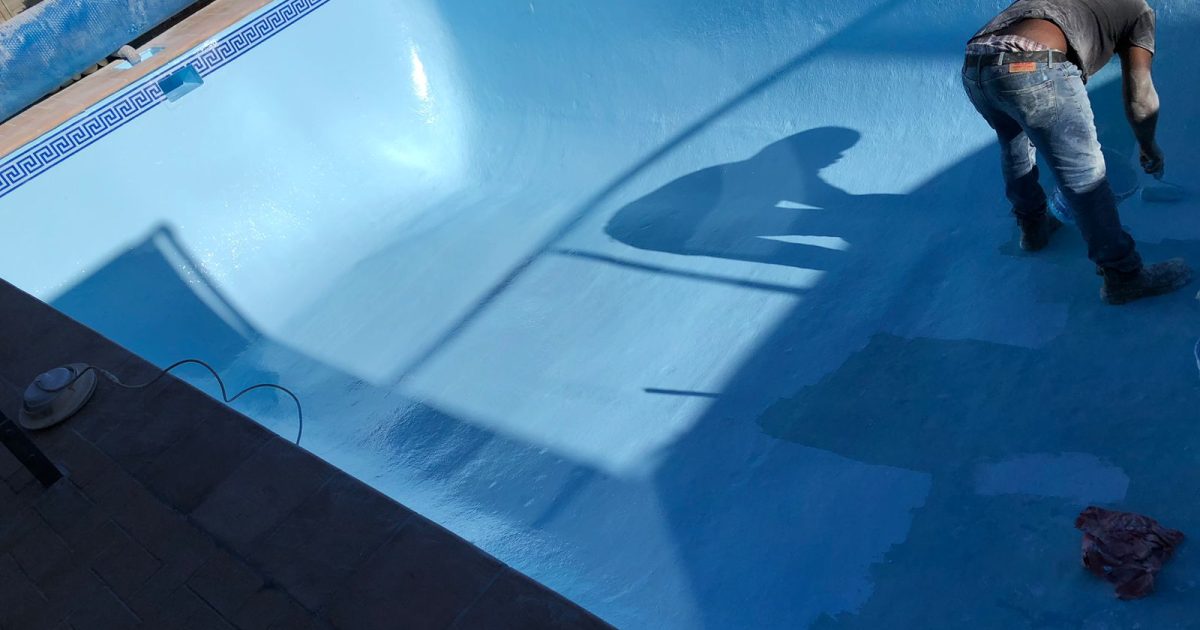 Pool technician painting the interior of a residential fibreglass swimming pool in Cape Town