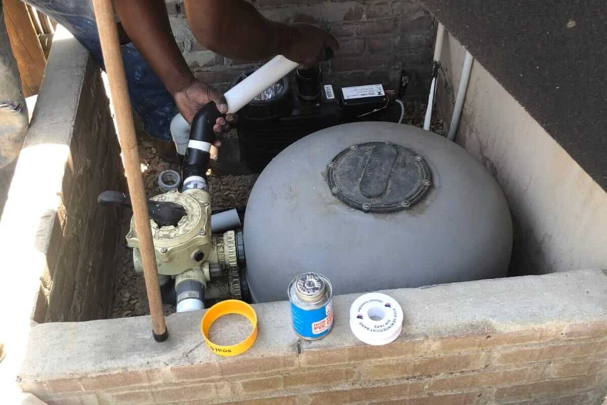 Swimming pool technician repairing pump and filtration system