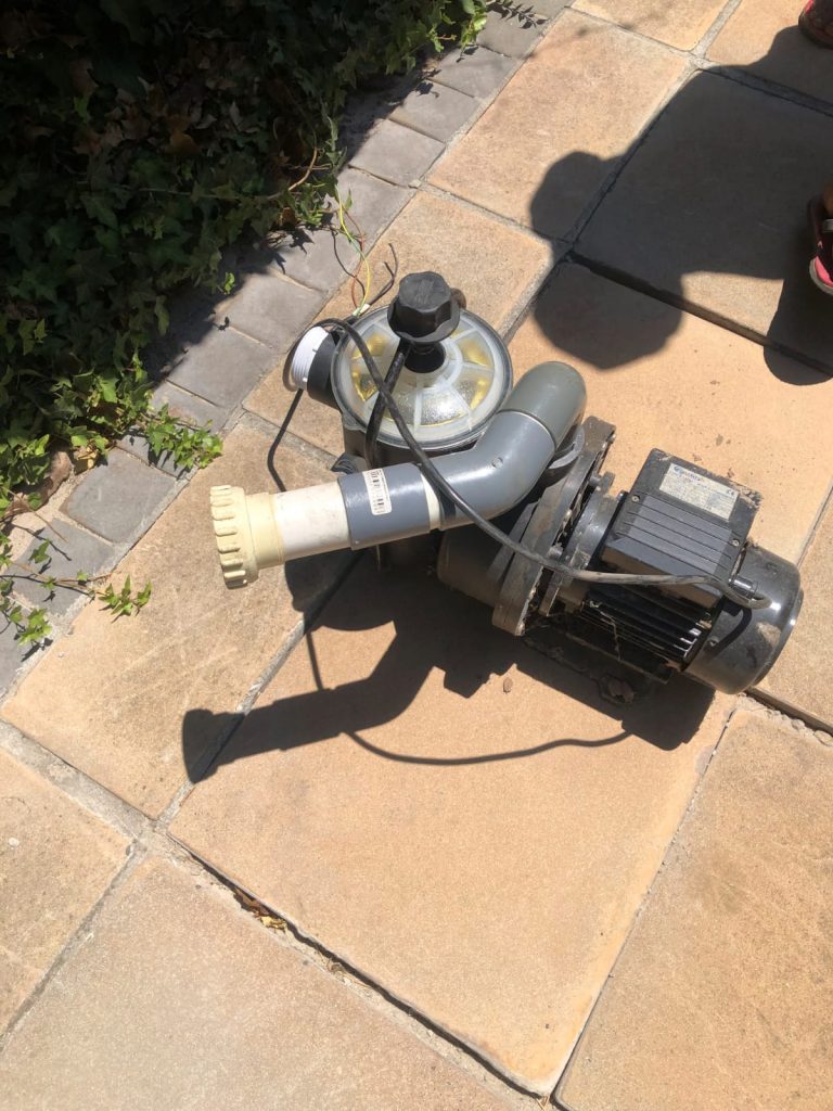 Worn pool pump lifted out for inspection after it started grinding and rattling