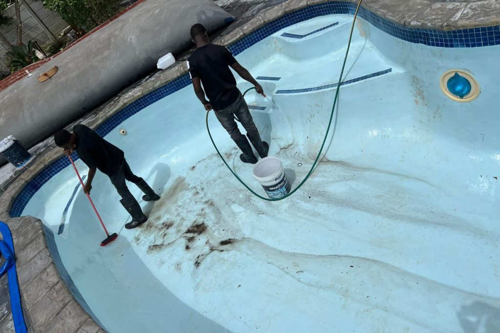 Brushing pool wall to remove algae in residential swimming pool