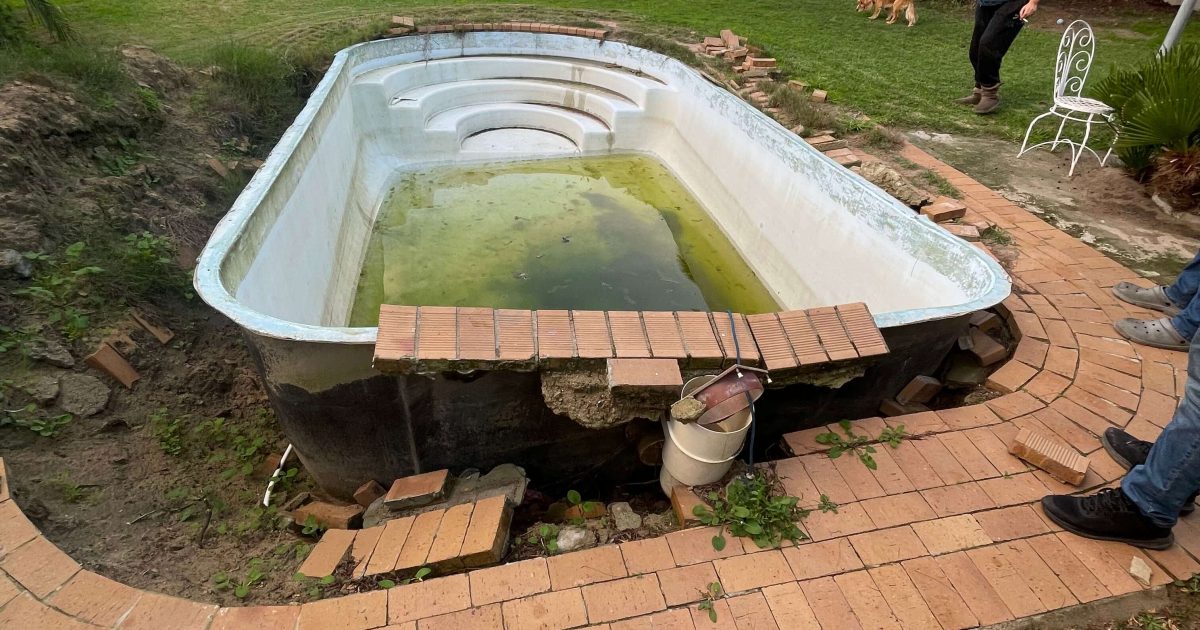 Damaged fibreglass pool shell lifted out of the ground due to hydrostatic pressure in a Western Cape backyard
