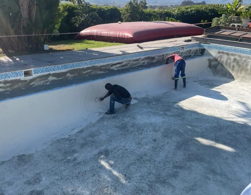 Technician resurfacing a marbelite swimming pool in Cape Town with new plaster finish for a smooth, durable surface