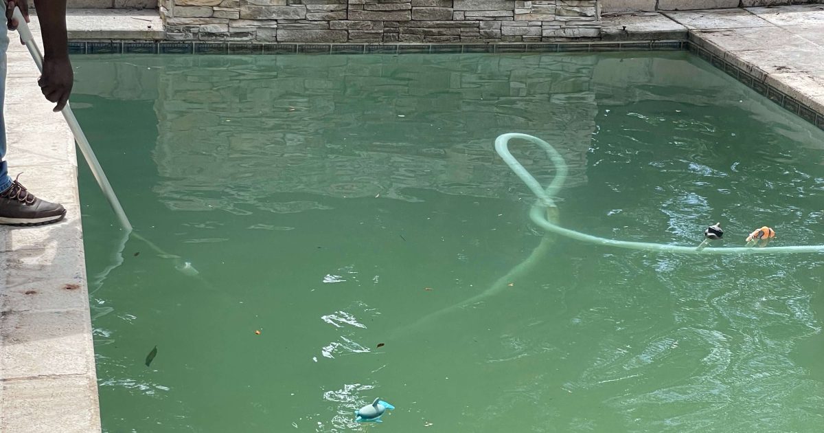 Technician vacuuming a fibreglass swimming pool manually in Cape Town, South Africa