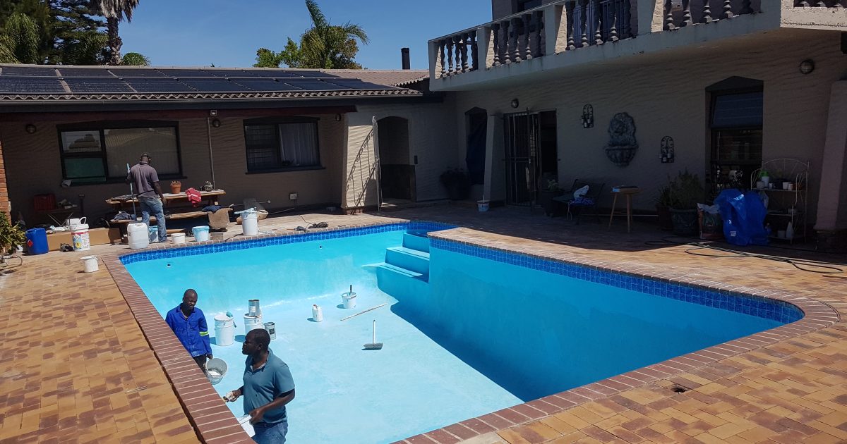 Old marbelite swimming pool in Noordhoek undergoing fibreglass lining and painting process by Pools Reno, showing mid-stage application for a durable, watertight pool finish.