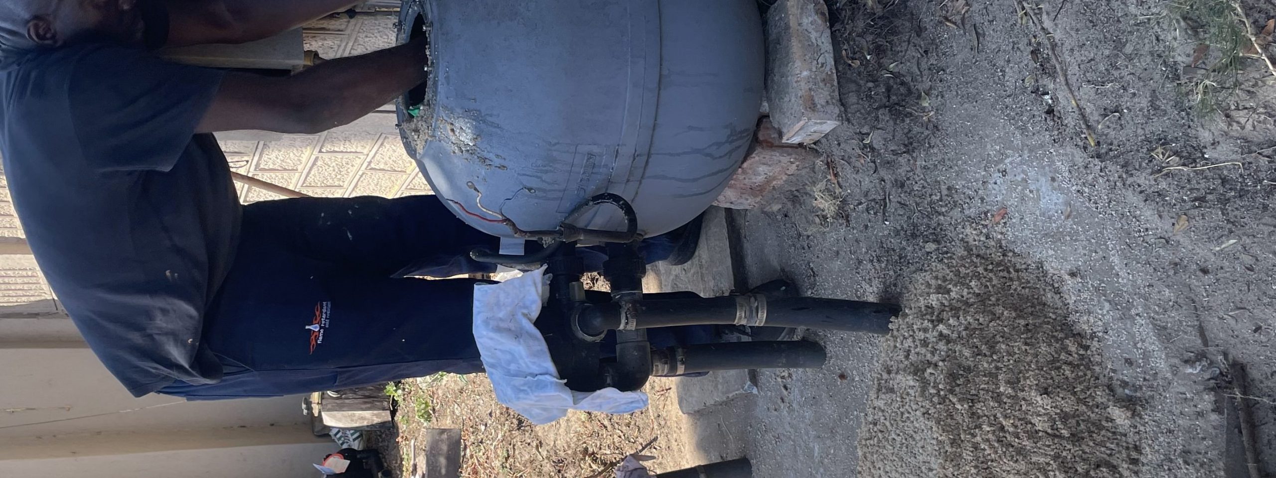 Pools Reno technician removing old sand from a 3 bag pool filter in Cape Town