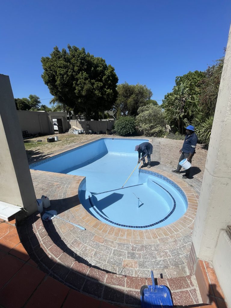 Fully painted fibreglass swimming pool with a glossy blue finish, completed by Pools Reno in Cape Town, showcasing expert workmanship and premium pool coating quality.