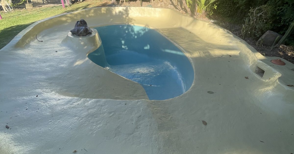 Newly fibrelined gunite beach entry swimming pool in Cape Town, beautifully finished with a two-tone blue and turquoise paint design by Pools Reno, highlighting smooth fibreglass workmanship and coastal-style elegance.