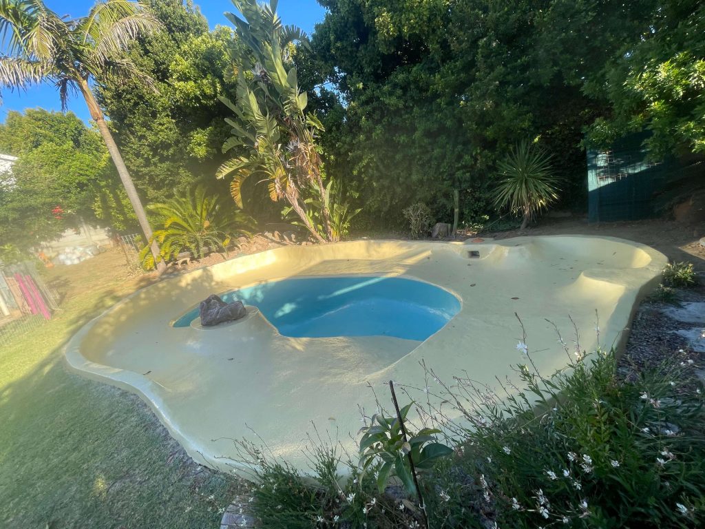 Stunning gunite beach-style swimming pool in Cape Town expertly fibreglass lined and painted in two colours by Pools Reno, showcasing a smooth finish and modern coastal design.