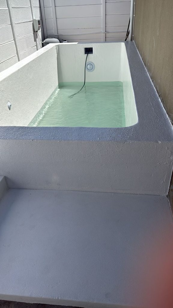 Newly completed fibreglass-lined concrete pool being filled with water in Cape Town