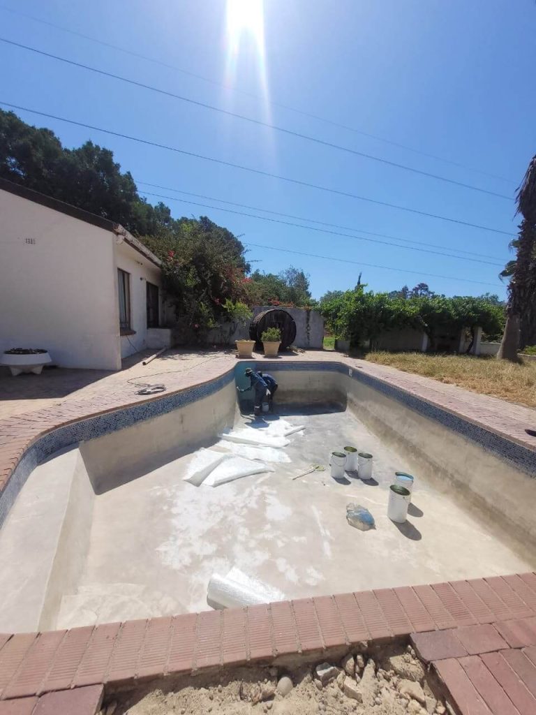 Professional deep cleaning of an old marbelite pool in Cape Town to remove algae and prepare the surface for fibreglass lining