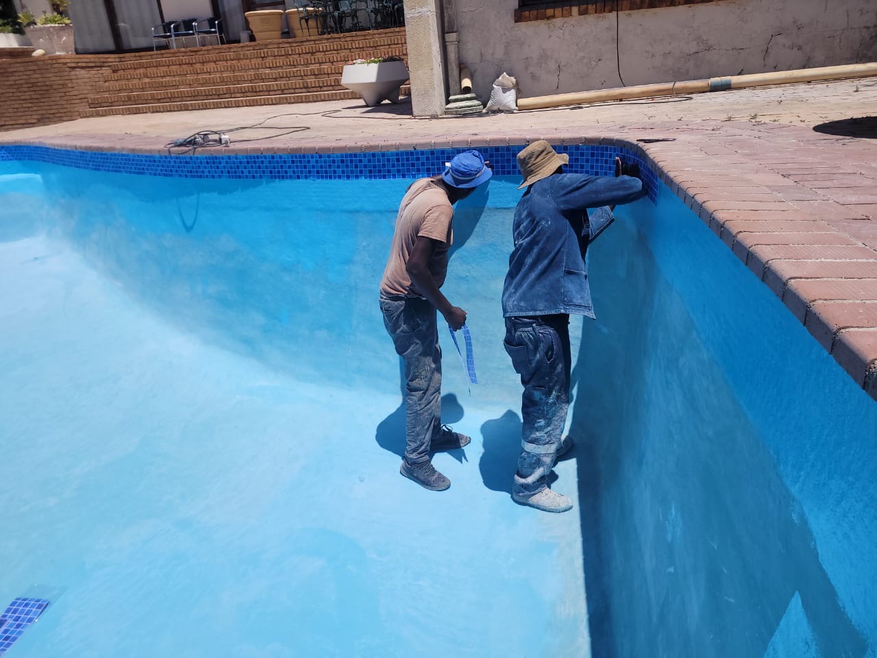 Tissue mosaic tiles being installed in a swimming pool to create a smooth, decorative finish in Cape Town