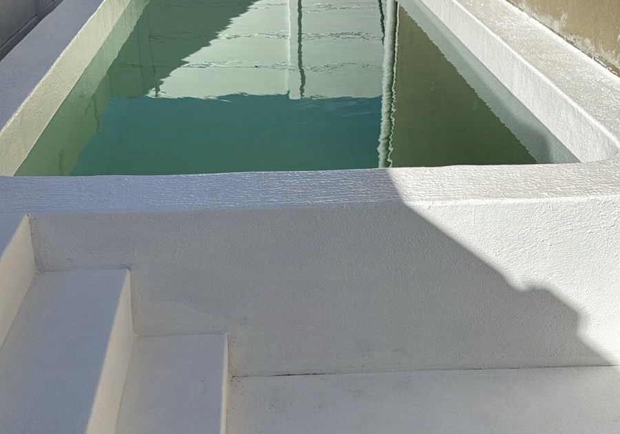 Newly completed fibreglass-lined concrete swimming pool in Cape Town with a smooth finish and crystal-clear water