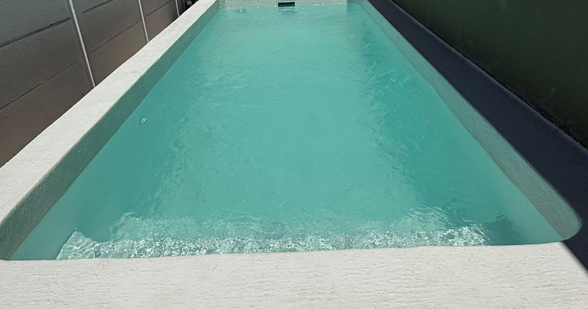 Newly fibreglass lined concrete swimming pool filled with clear, sparkling water after professional installation in Cape Town