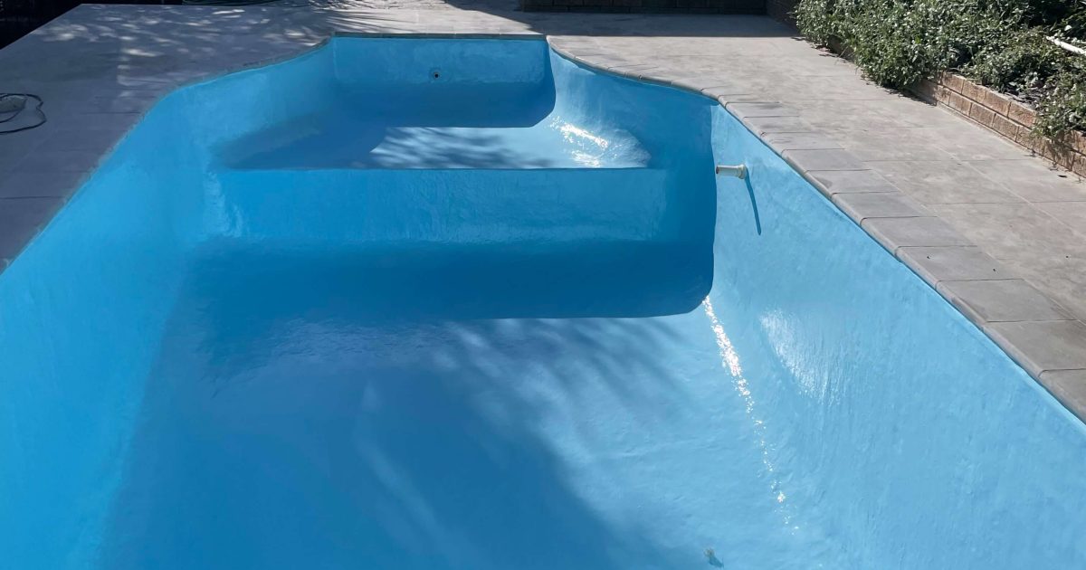 Recently deep cleaned swimming pool with a new fibreglass lining completed by Pools Reno in Cape Town, showcasing a smooth, watertight finish and crystal-clear water.