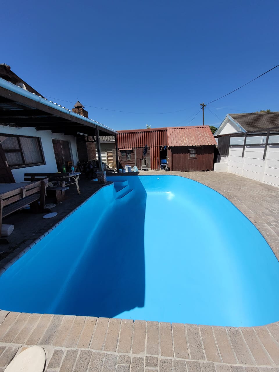 Newly renovated swimming pool in Kenridge, Cape Town, featuring fibreglass lining, fresh pool paint, surface repairs, and modern pool finishes by Pools Reno
