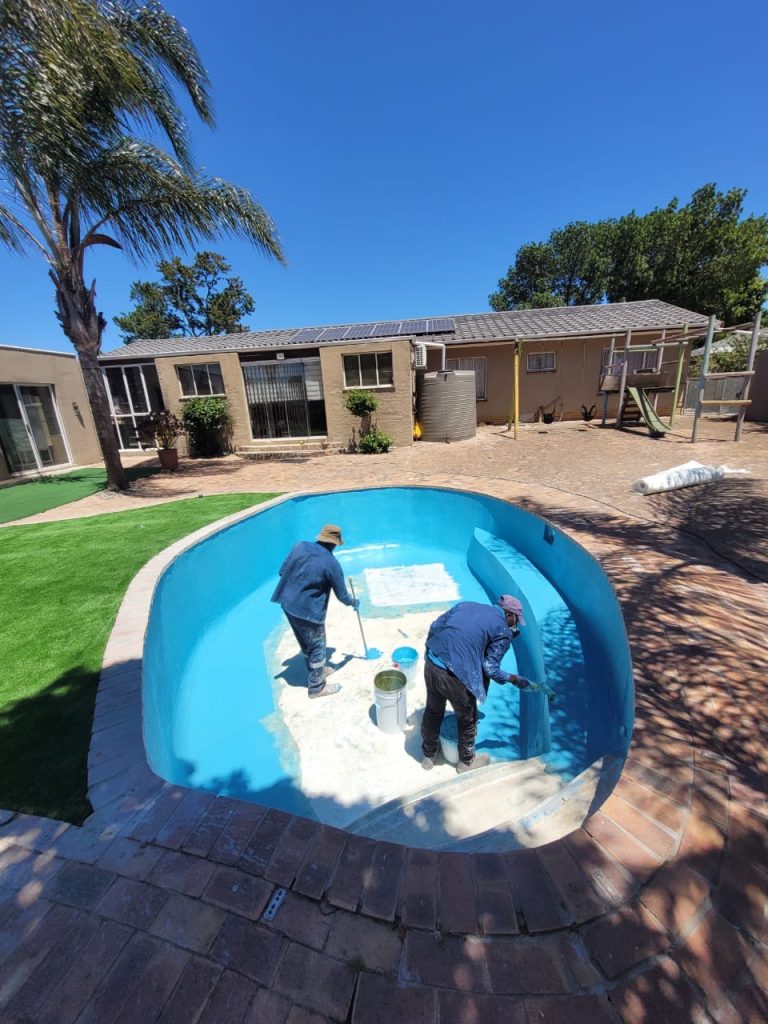 Tissue mosaic tiles being carefully installed inside a fibreglass lined concrete swimming pool during renovation in Cape Town