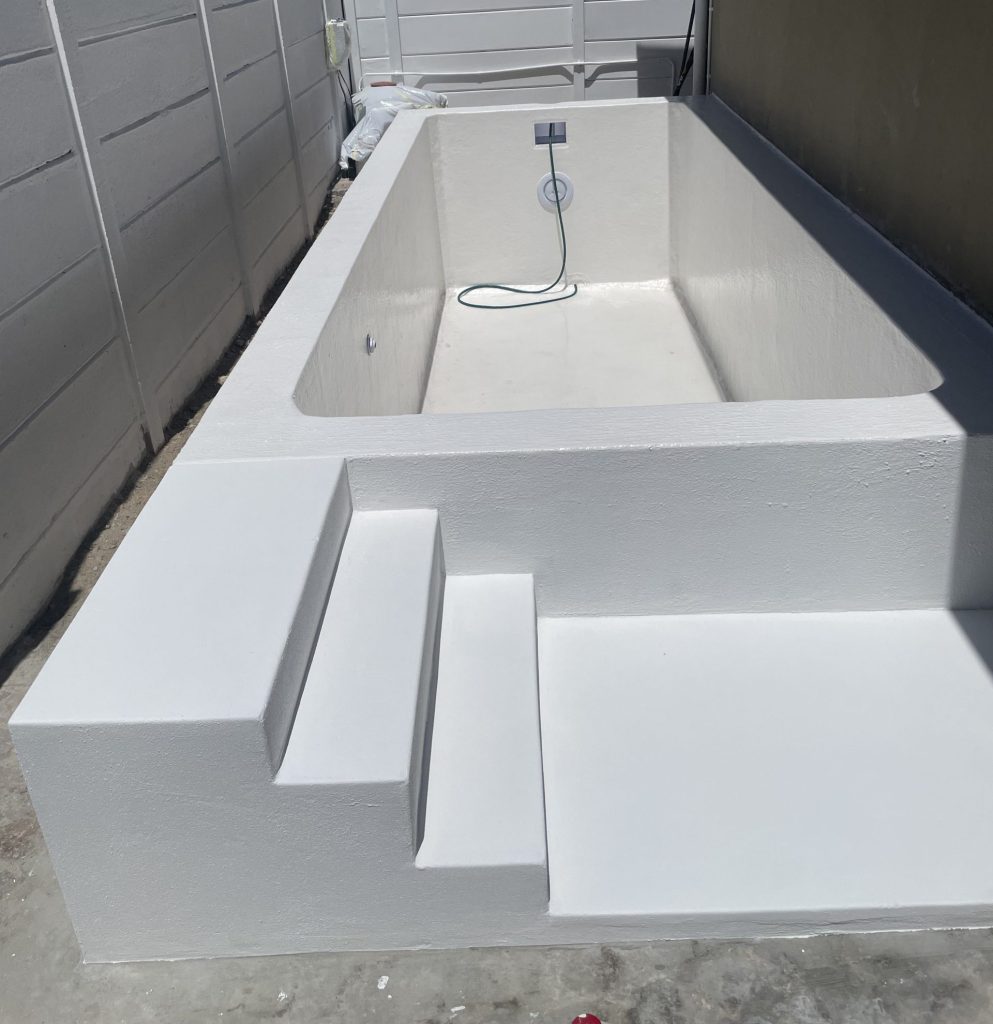 Underwater pool light fitted in the wall of a newly built plunge pool before filling