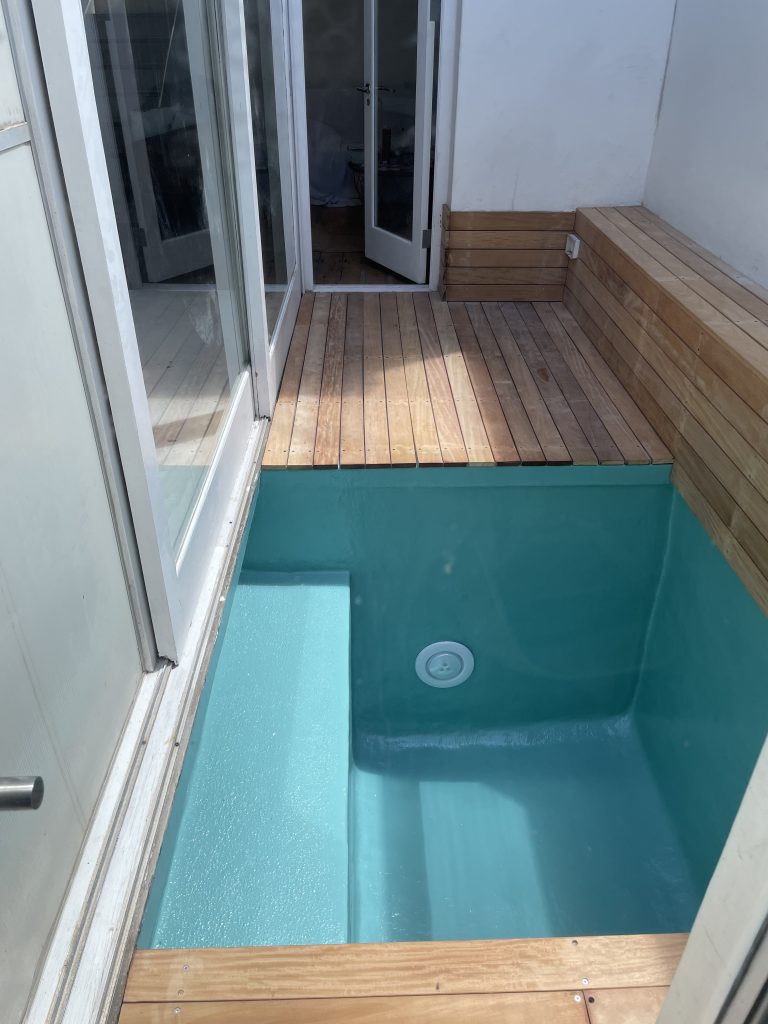 Fibreglass-lined splash pool featuring smooth waterproof finish, crystal-clear water, and stylish wooden decking, installed by Pools Reno experts