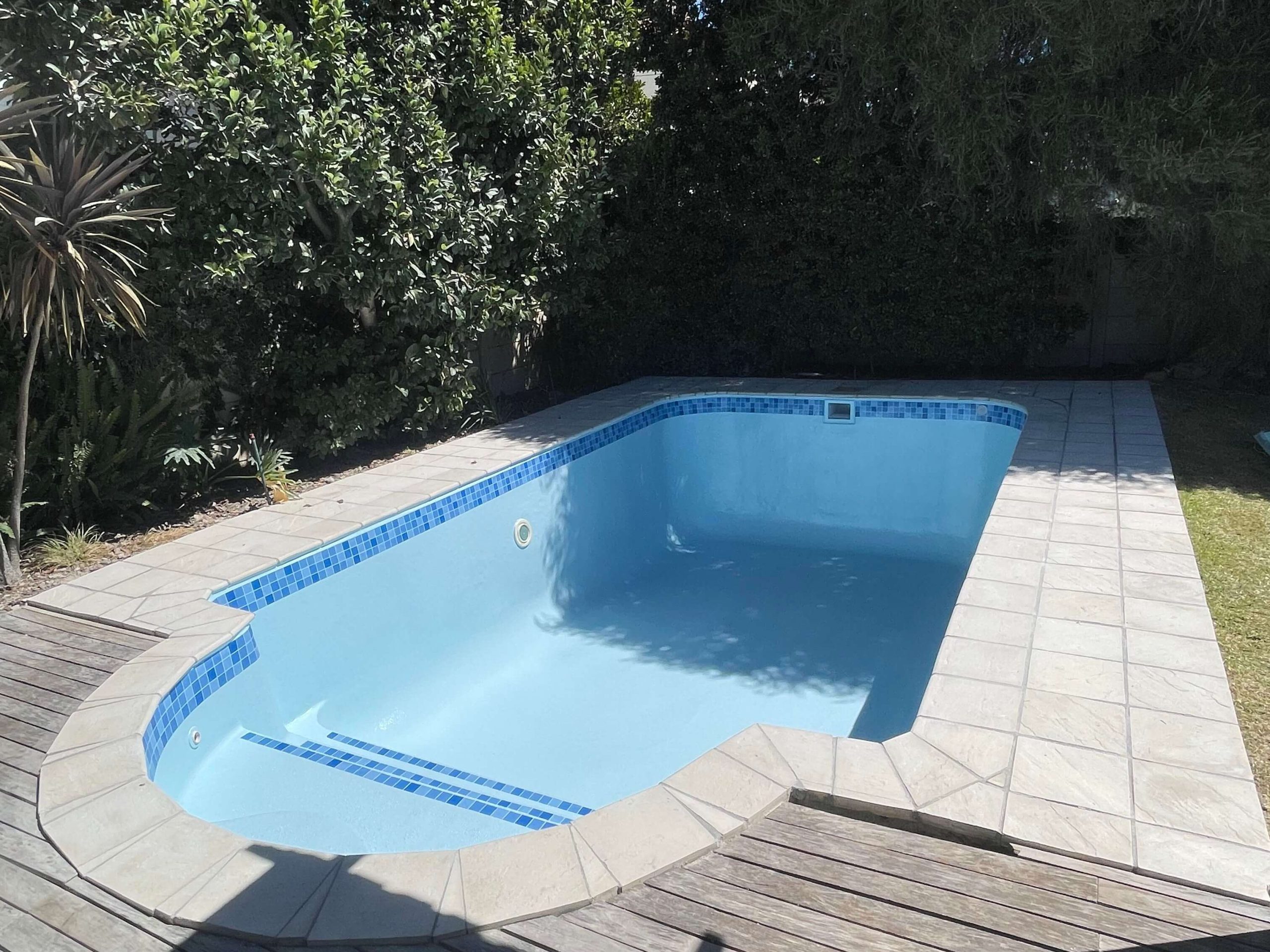 Newly fibreglass lined and painted light blue swimming pool in Cape Town with a smooth durable finish after professional pool resurfacing and renovation