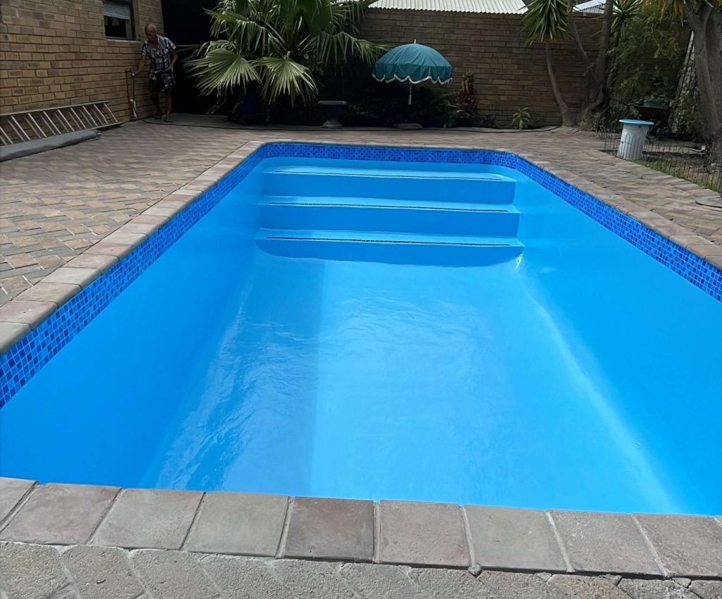 Smooth blue fibreglass lined swimming pool after relining and painting in Kleinmond Western Cape