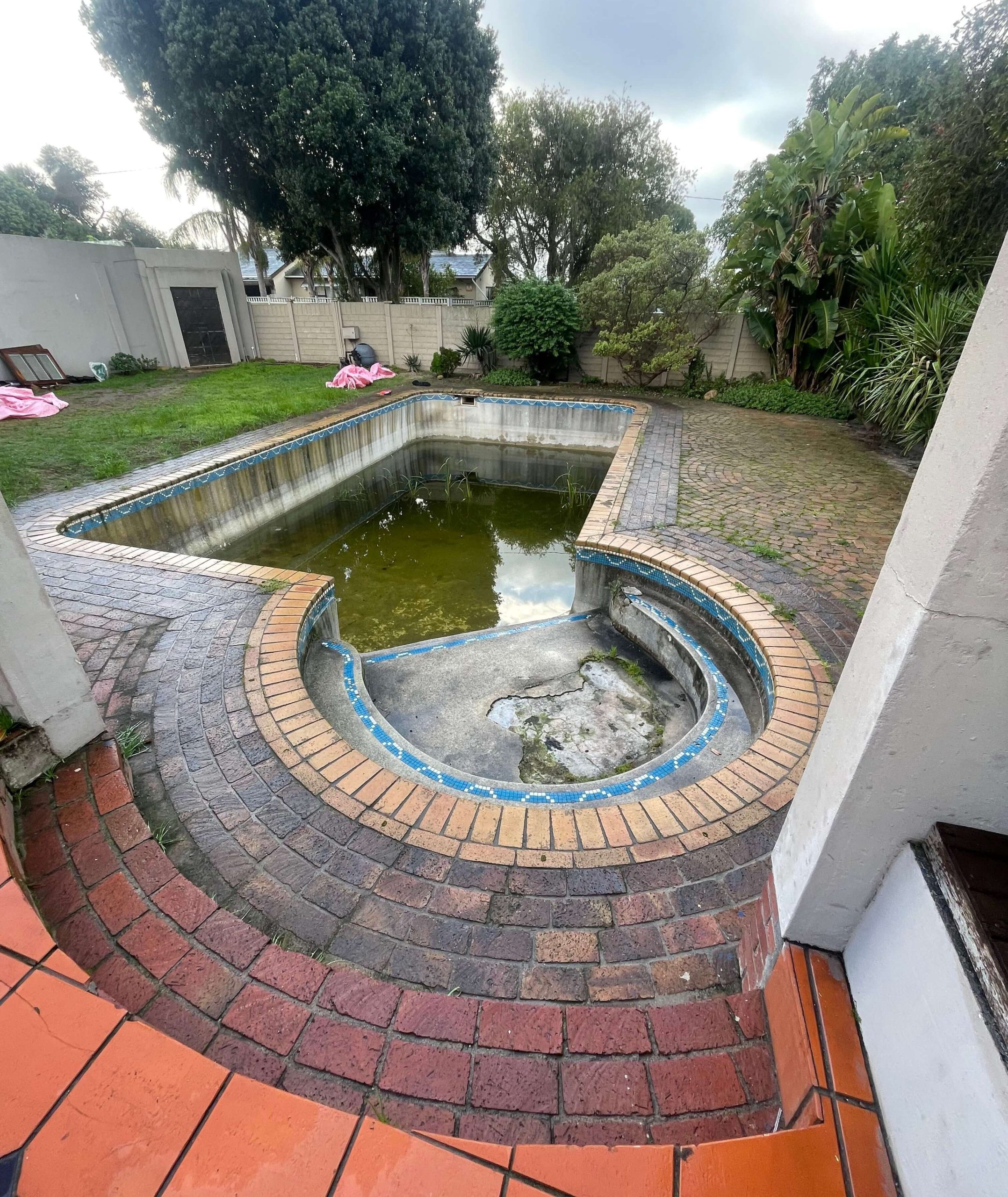 Damaged marbelite swimming pool with cracks and stains requiring renovation in Cape Town