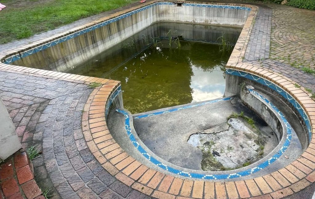 Swimming pool in Langebaan showing surface wear, cracks and corrosion caused by coastal conditions