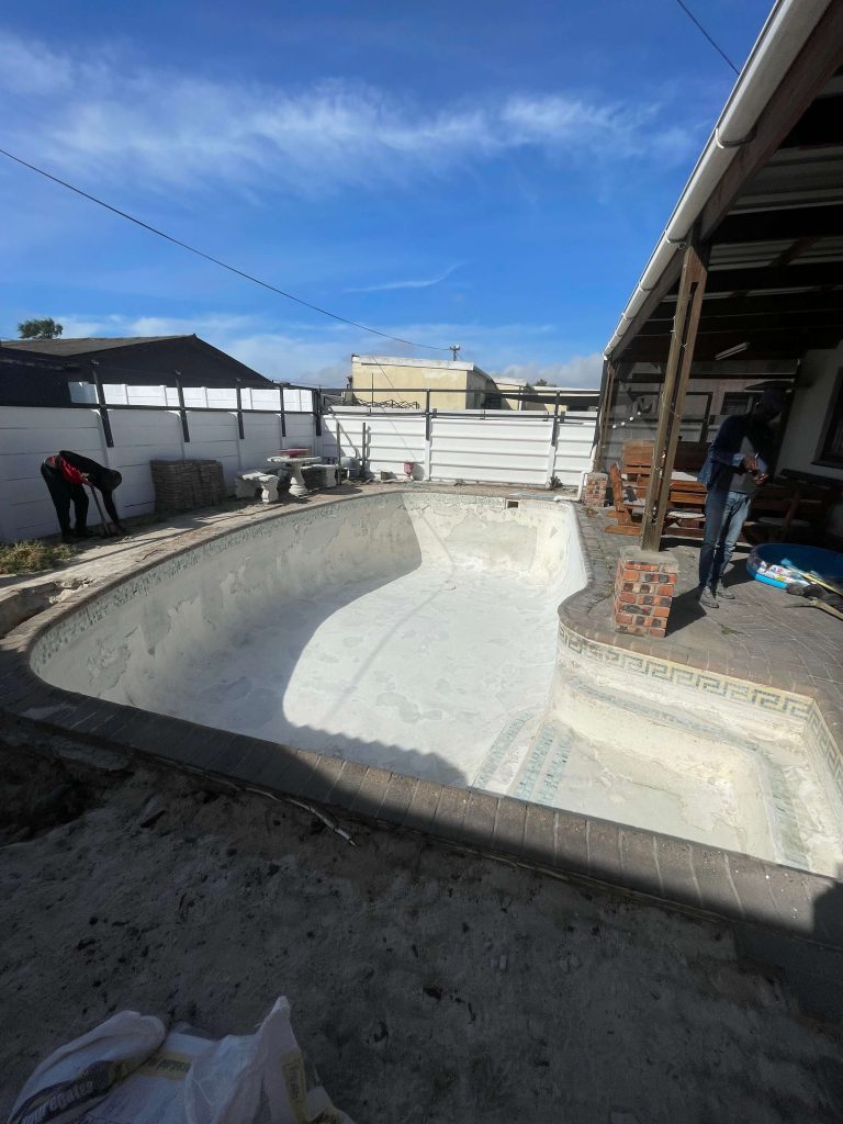 Old concrete swimming pool in Parow Cape Town before fibreglass lining showing worn surface cracks and ageing pool structure
