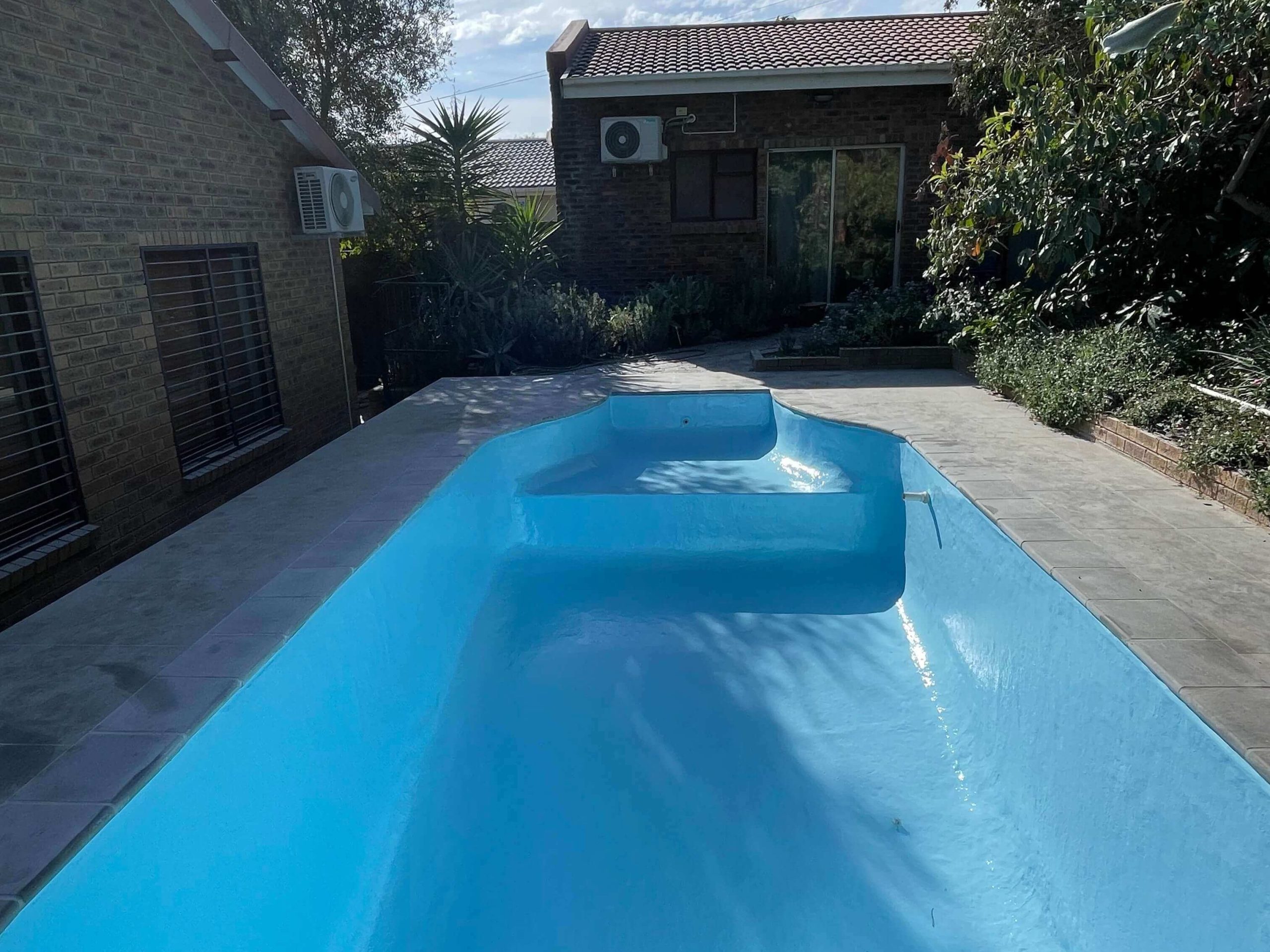 Newly fibreglass lined and painted sky blue swimming pool in Cape Town showing a smooth durable finish after professional pool resurfacing