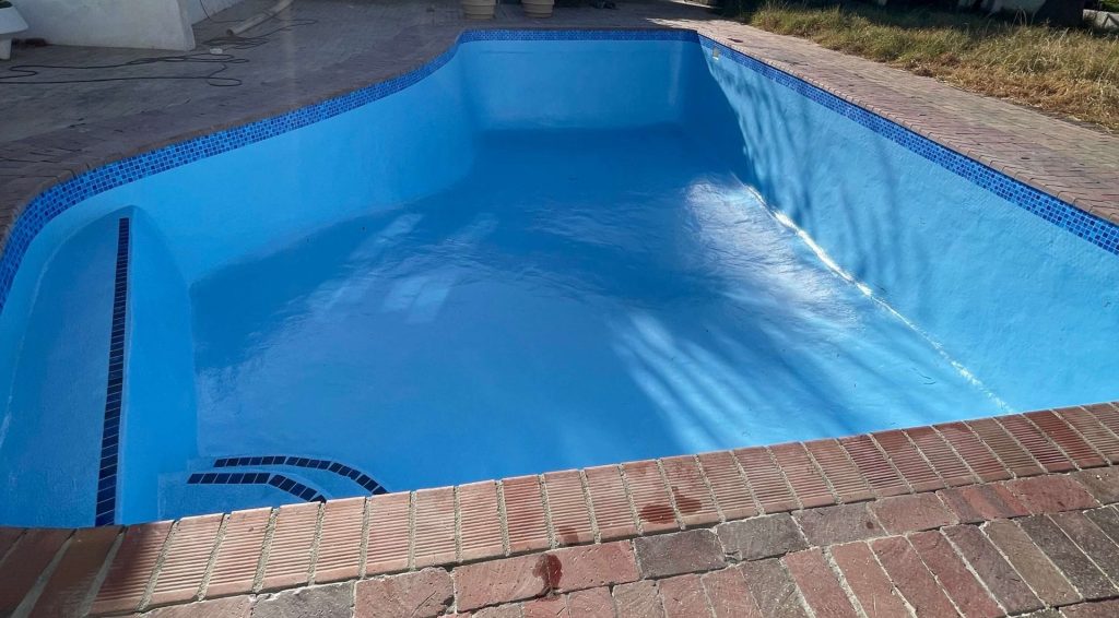 Clean fibreglass lined swimming pool after renovation showing smooth modern blue surface in Cape Town
